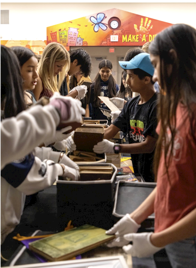 8th grade students examine relics from the past in a real-life history lesson.