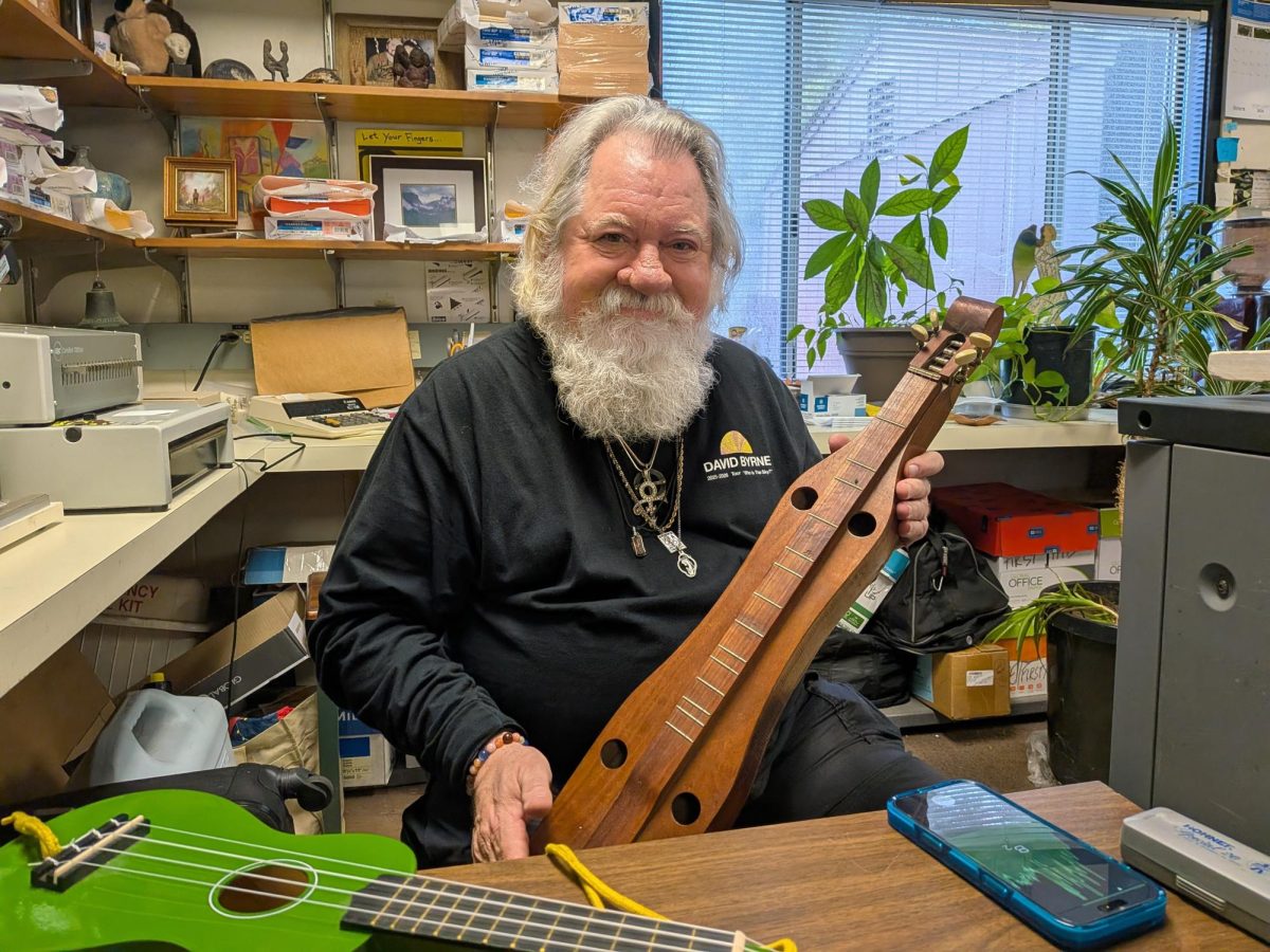 Nick Muntean holds one of his dulcimers on Feb. 18 in the Foothill College printshop. He plays a variety of instruments such as dulcimer and harmonica.
