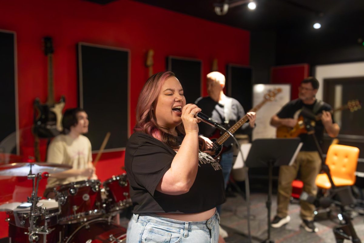 Coppell School of Rock owner Melissa Birchett fills in for vocals on 
“Danger Zone” by Kenny Loggins during an adult band practice. Birchett’s empowering voice has a great and positive influence on all students at School of Rock Coppell. Photo by Maren Wiley