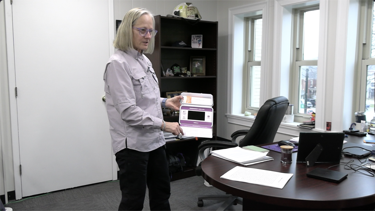 Jan Rader, spokesperson for the ONEbox, displays the earliest model of the overdose reversal kit on her office shelf as a reminder of the project’s humble beginnings. (Photo by Riley Burnett)