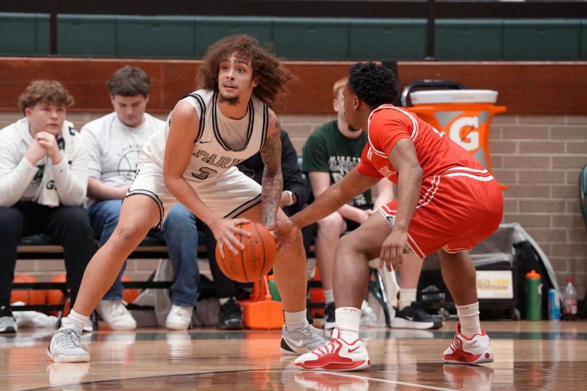 Senior Koltan Lopez looks up towards his teammates while holding the ball above the three-point line. On Feb. 27, the Panthers took on West Brook in the area finals and lost 52-22. 