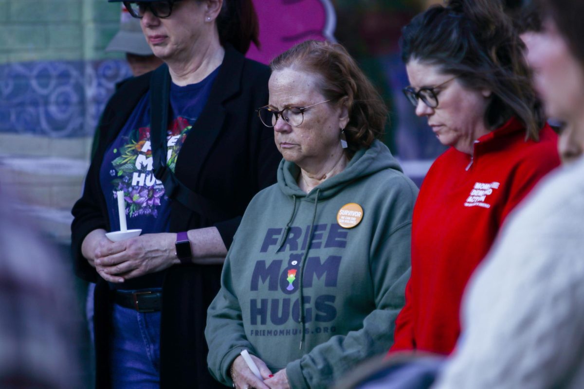 Taking a moment of silence, Barb Gienapp bows her head with other vigil attendees in recognition of the violence in downtown Iowa City the previous day. "I think it's important for us to support the community in any way we can. We're apolitical, and this is an apolitical event, so we're allowed to come out for these events and just be here for our community," Geinapp said. "Gun violence was a part of my early life, and so it's something that has affected me my whole life."