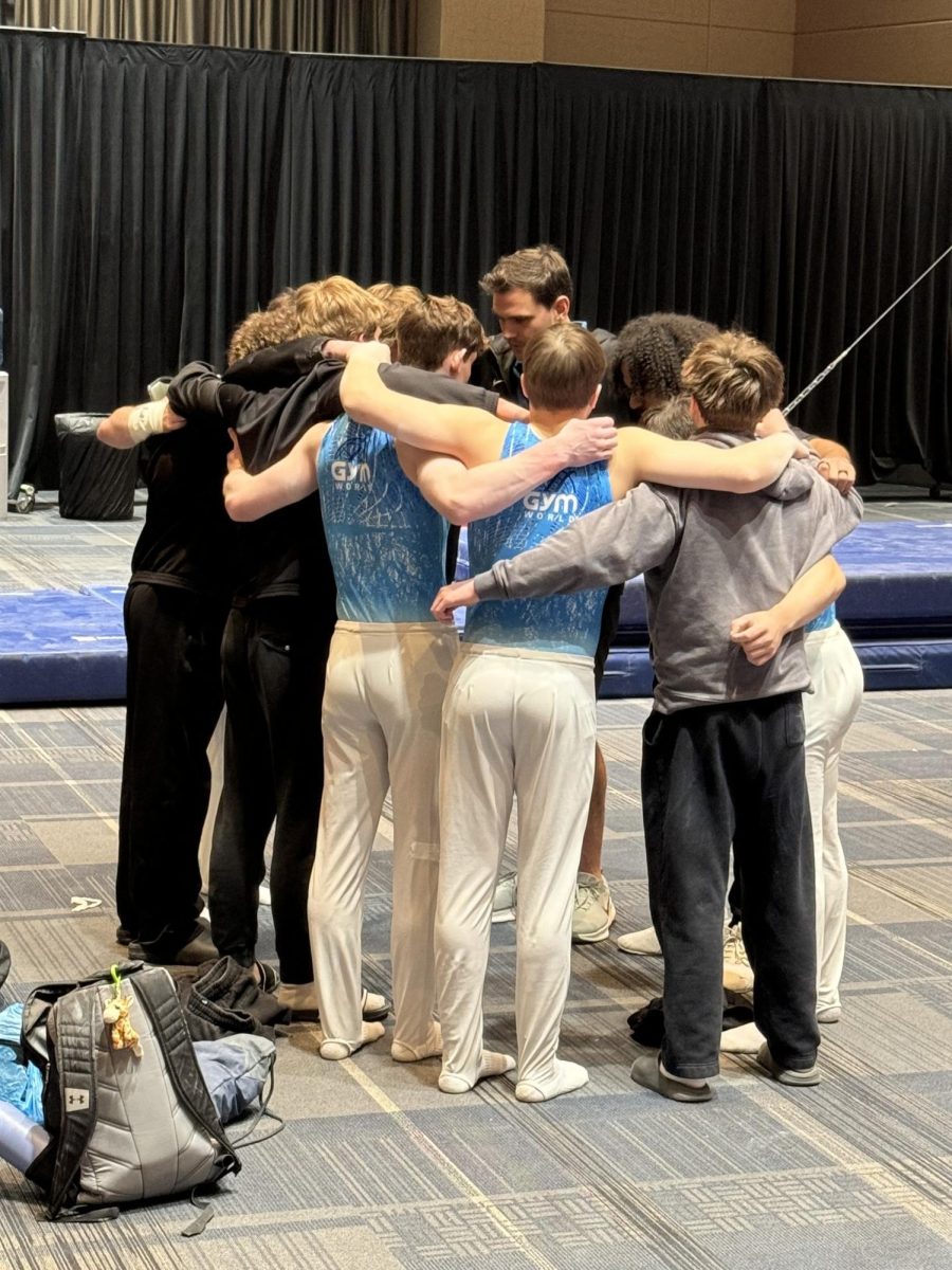 Allen and Gretter participate in a team huddle before a recent competition.