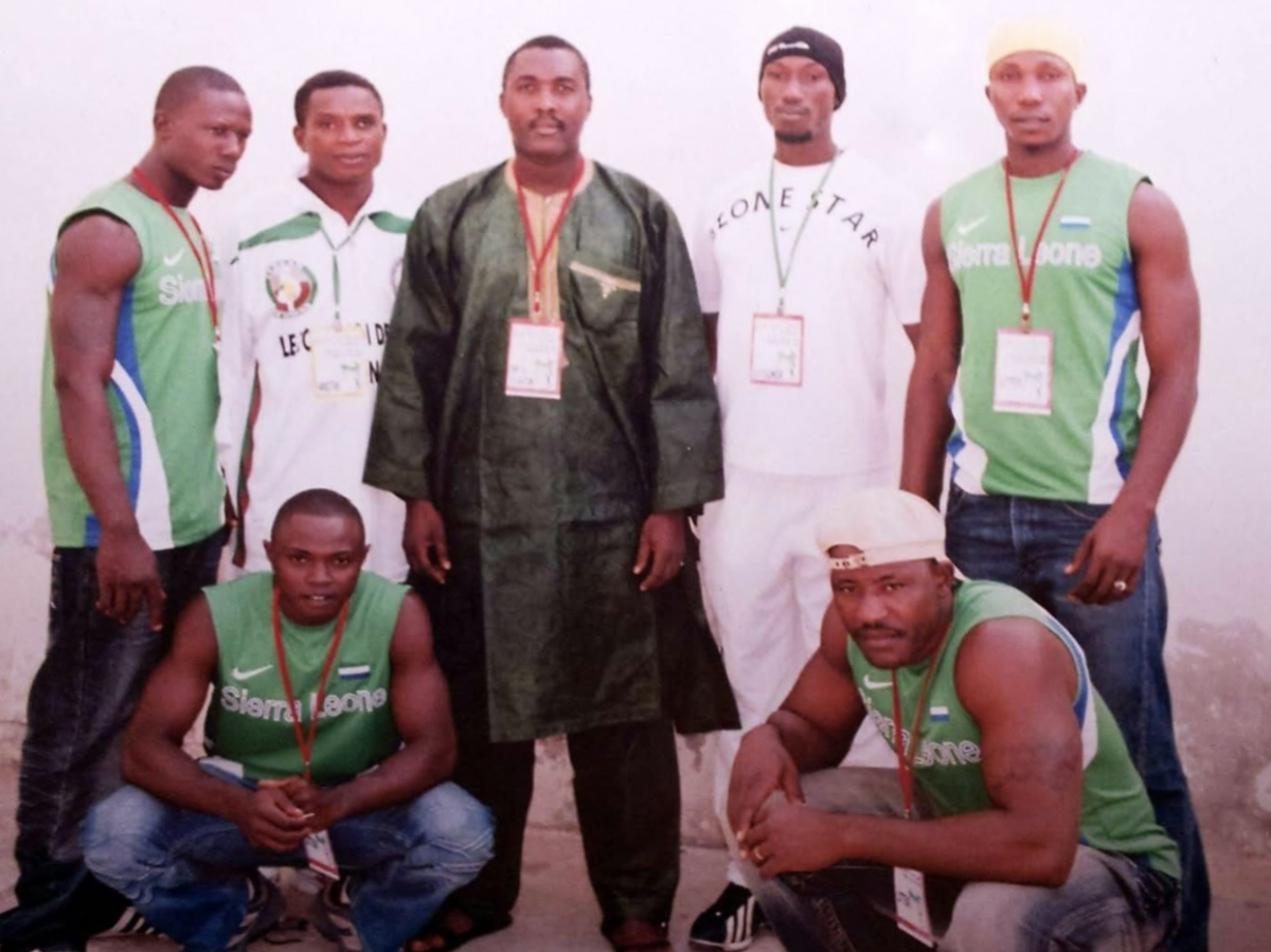 Kamara stands with his teammates and the President of the Sierra Leone Wrestling Association. Kamara said he trained in a variety of combat sports, such as kickboxing and wrestling.