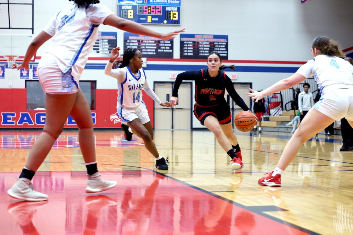 Senior Yeiry Zamudio treks through three opposing players at the away game against Oak Ridge High School on Jan. 13.
